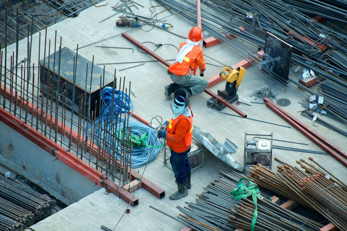 Pekerja konstruksi dan alat berat pada proyek infrastruktur strategis nasional jembatan dan jalan layang