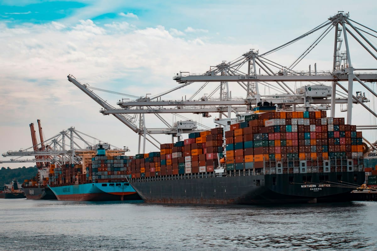 Pelabuhan kontainer peti kemas modern internasional dengan kapal kargo saat fajar menyingsing